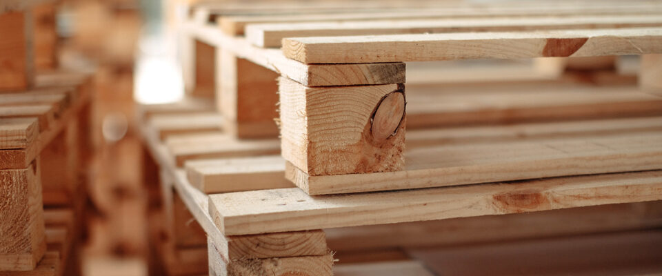 Close-up image of stacked wooden pallets for reusable packaging and transportation.