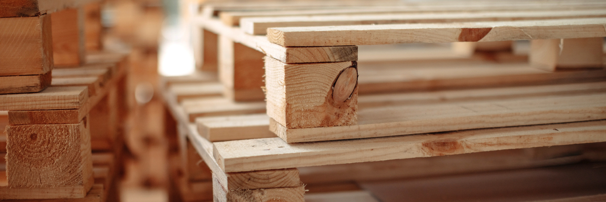 Close-up image of stacked wooden pallets for reusable packaging and transportation.